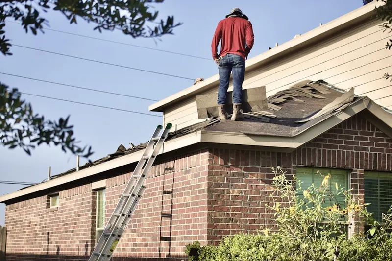 Professional roofer working on a residential roof in Raco